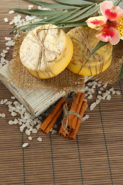 Мыло ручной работы и морская соль на сером бамбуковом коврике — стоковое фото
