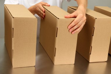 gri arka plan üzerinde Konveyör bant kutuları ile çalışan işçi