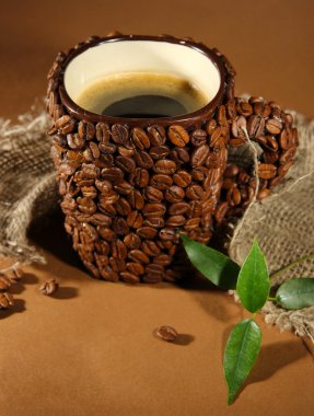 kahverengi zemin üzerine kahve çekirdekleri fincan