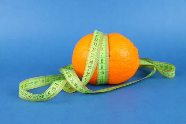 Orange mit Maßband, auf farbigem Hintergrund — Stockfoto