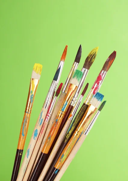 Many brush in paint on green background — Stock Photo, Image