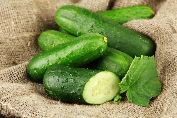 Leckere grüne Gurken auf Sacktuch Hintergrund — Stockfoto