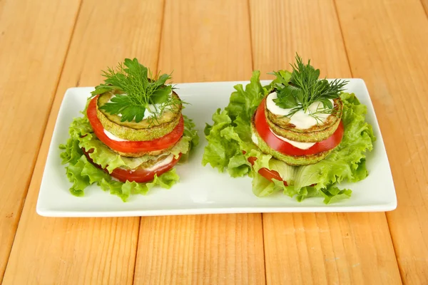 Leckere geröstete Knochenmark und Tomatenscheiben mit Salatblättern, auf Holzgrund — Stockfoto