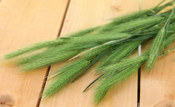 Muchas espiguillas sobre fondo de madera — Foto de Stock