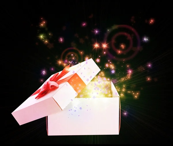 Gift box with red ribbon with sparkles on black background — Stock Photo, Image