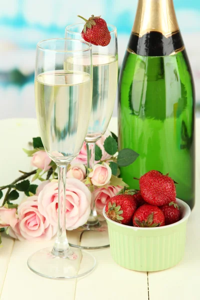 Romantische Stilleven met champagne, aardbei en roze rozen, op lichte achtergrond — Stockfoto