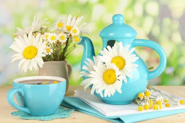 Beautiful bouquet chamomiles in teapot on wooden table on natural background — Stock Photo, Image