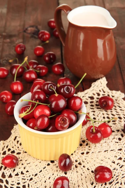 Ripe red cherry berries in bowl on wooden table close-up — Stock Photo, Image