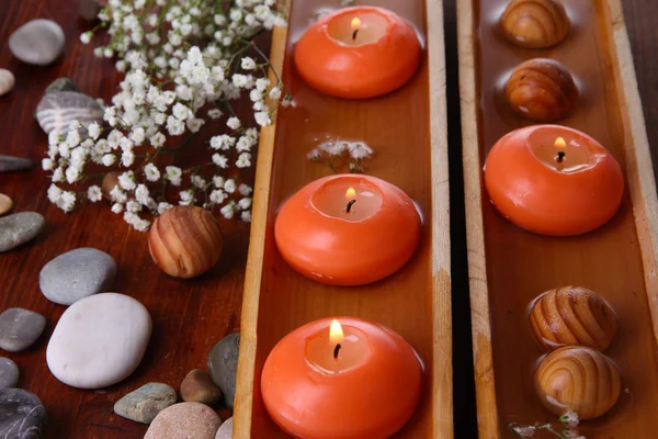 Krásné svíčky ve vodě na dřevěný stůl detail — Stock fotografie