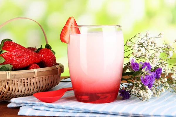 Delicious strawberry yogurt in glass on wooden table on natural background — Stock Photo, Image