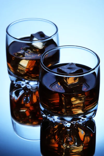 Bicchieri di brandy con ghiaccio su sfondo blu — Foto Stock