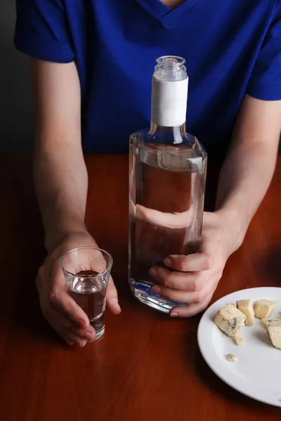 Un homme ivre boit de la vodka à table close-up — Photo