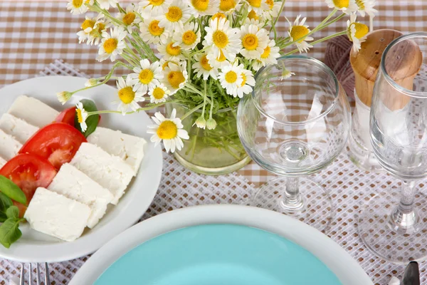 Tischdekoration mit Kamille auf karierter Tischdecke — Stockfoto