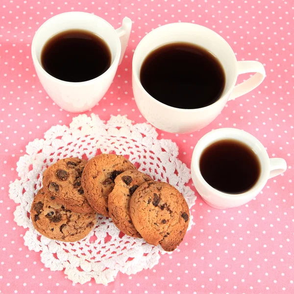 Xícaras de café com biscoitos em guardanapo rosa — Fotografia de Stock