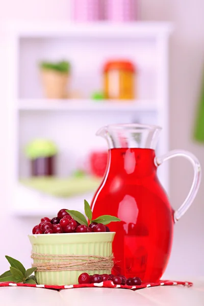 Jarro de suco de cranberry e cranberries vermelhos na mesa — Fotografia de Stock