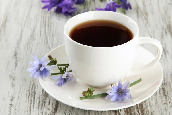 Чашка чая с цикорием, на деревянном фоне — стоковое фото