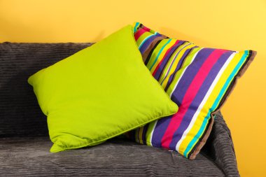 kanepede sarı arka plan üzerinde renkli yastıklar