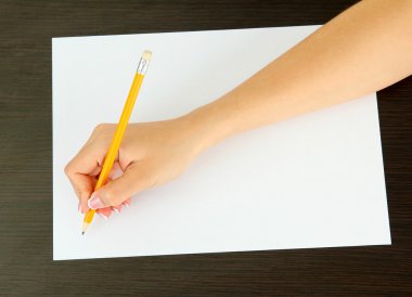 ahşap zemin üzerinde beyaz kağıt kalem ile el