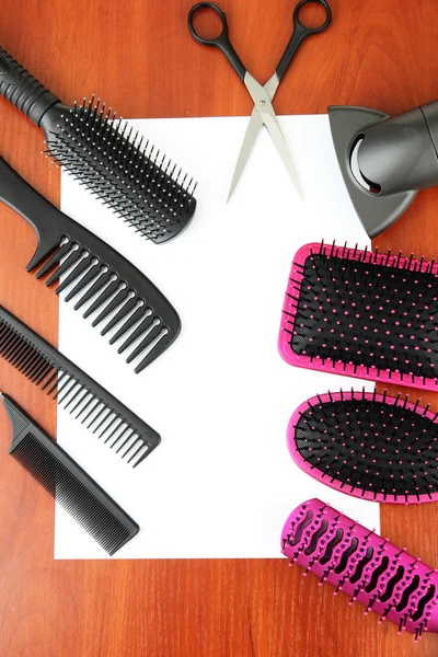 Comb brushes, hairdryer and cutting shears,on wooden background — Stock Photo, Image