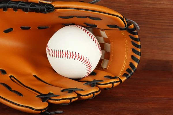 Honkbal handschoen en bal op houten achtergrond — Stockfoto