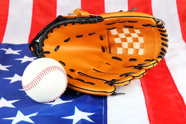 Guante de béisbol y pelota sobre fondo de bandera estadounidense — Foto de Stock