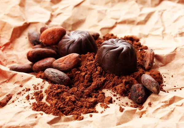 Samenstelling van chocolade snoepjes en cacao op bruine achtergrond — Stockfoto