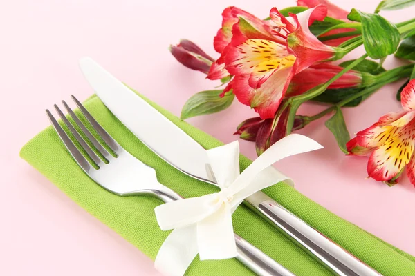 Festive dining table setting with flowers on pink background — Stock Photo, Image