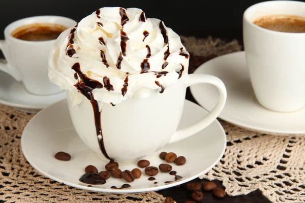 Cup of whipped cream coffee on wooden table close up — Stock Photo, Image