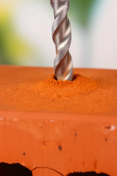 Close-up image vrtání díry na cihly, na světlé pozadí — Stock fotografie