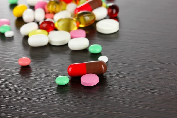 Sortiment av piller, tabletter och kapslar på träbord — Stockfoto