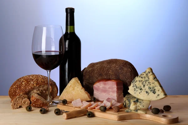 Exquisito bodegón de vino, queso y productos cárnicos — Foto de Stock