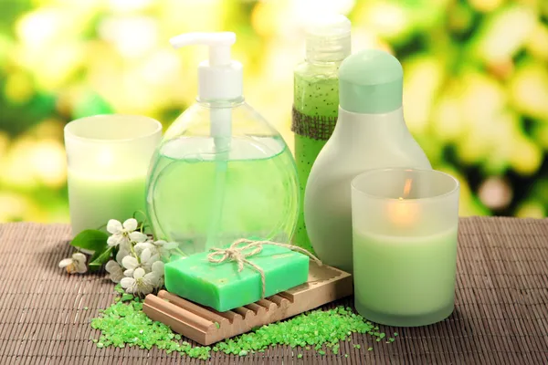 Botellas de cosméticos y jabón natural hecho a mano sobre fondo verde — Foto de Stock