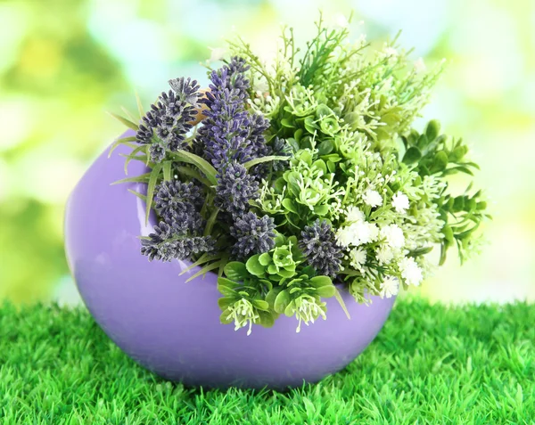 Pot avec des fleurs sur l'herbe sur le fond de la nature — Photo