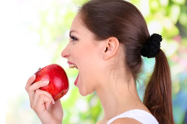 Young woman with apple on bright background — Stock Photo, Image