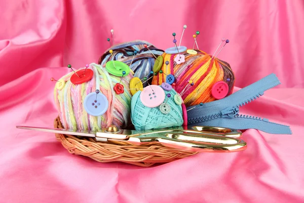 Colorful buttons and multicolor wool balls, on color fabric background — Stock Photo, Image