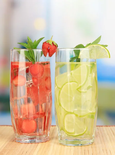 Vasos de bebidas de frutas con cubitos de hielo en la mesa en la cafetería — Foto de Stock