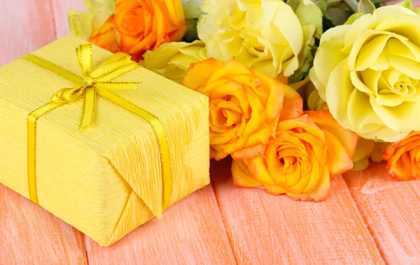 Bellissimo mazzo di rose con regalo sul tavolo primo piano — Foto Stock