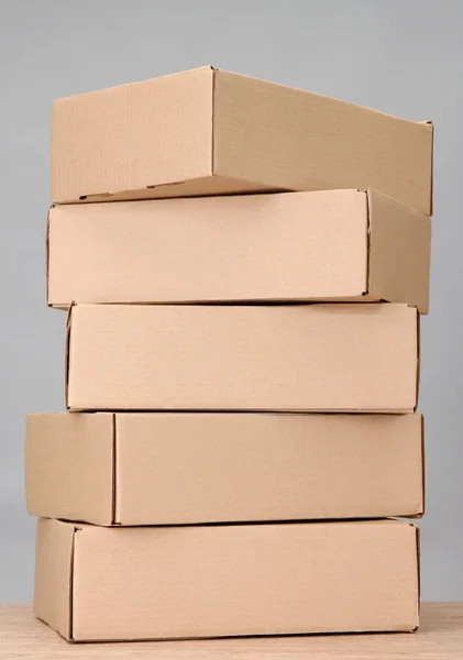 Parcellák dobozok fából készült asztal, a szürke háttér — Stock Fotó