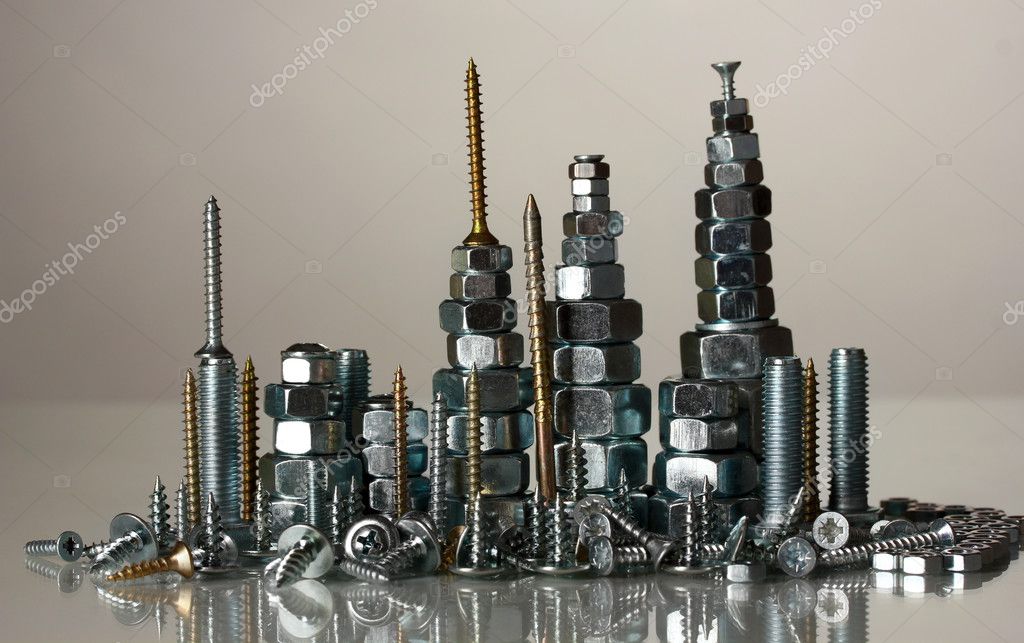 Many types of metal bolts, screws and nuts on grey background Stock