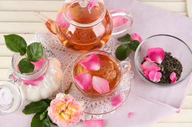 Kettle ve çay gülü peçete ahşap zemin üzerinde gelen