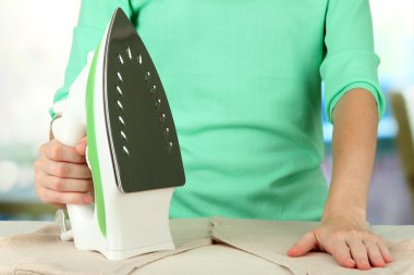 kadın eli parlak arka plan üzerinde elbise Ütü