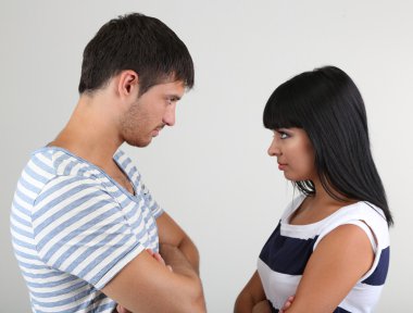 Loving couple quarrel on grey background