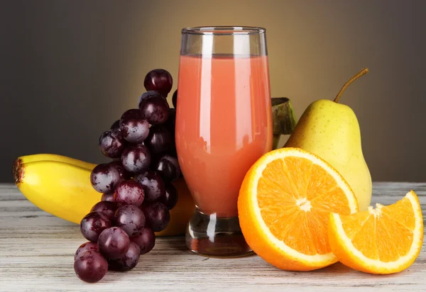 Copo de suco fresco na mesa no fundo cinza — Fotografia de Stock