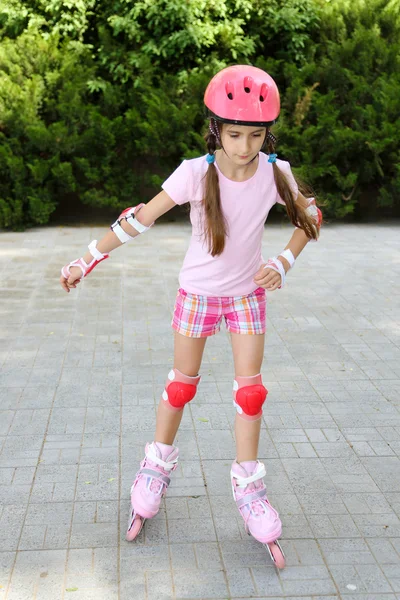 Petite fille en patins à roulettes au parc — Photo