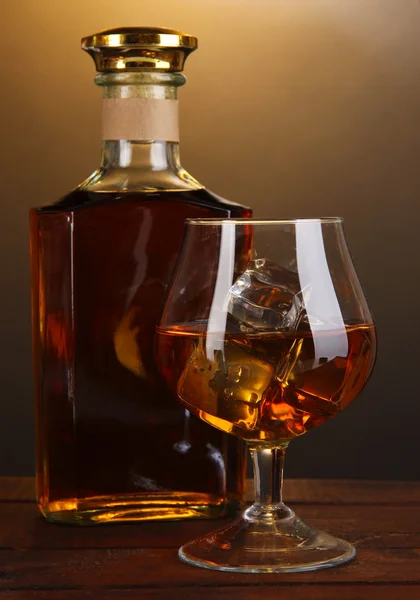 Brandy con hielo sobre mesa de madera sobre fondo marrón — Foto de Stock