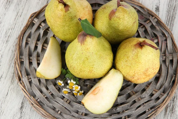 Peren op gevlochten lade op houten tafel — Stockfoto