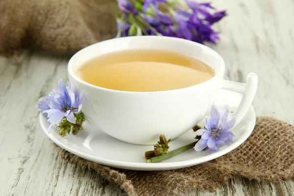 Чашка чая с цикорием, на деревянном фоне — стоковое фото