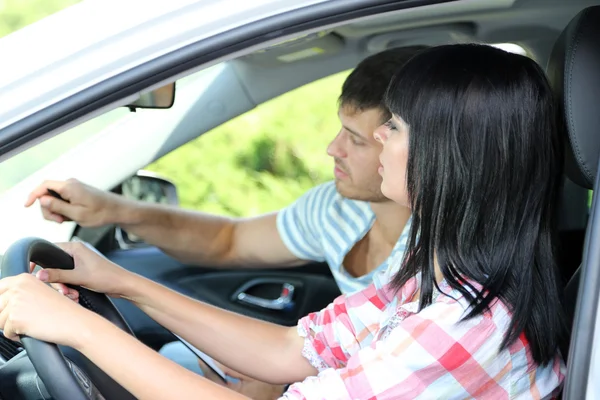 Beautiful young woman taking driving lesson — Stock Photo, Image