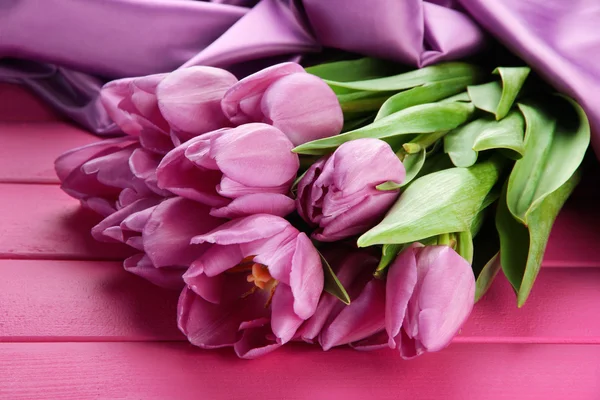 Beau bouquet de tulipes violettes sur fond de bois rose — Photo