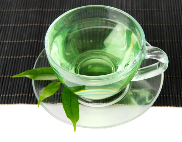 Tasse transparente de thé vert sur tapis de bambou, isolée sur blanc — Photo